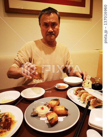 中国茶ハイを飲みながら皮から作ったギョーザを食べる男性 137016960