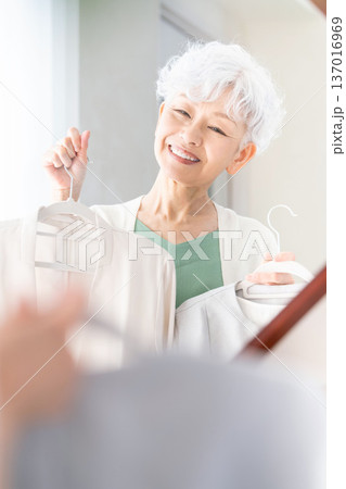 鏡の前で洋服選びをするシニア女性 137016969