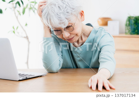 パソコンの前で不調を感じるシニア女性 137017134