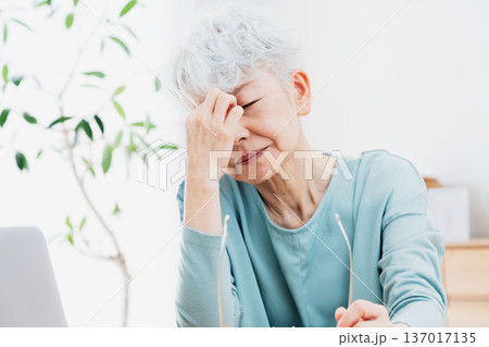 パソコンの前で不調を感じるシニア女性 137017135