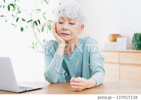 パソコンの前で不調を感じるシニア女性 137017138