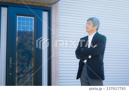 社屋建物の前で考える60代男性 137017783