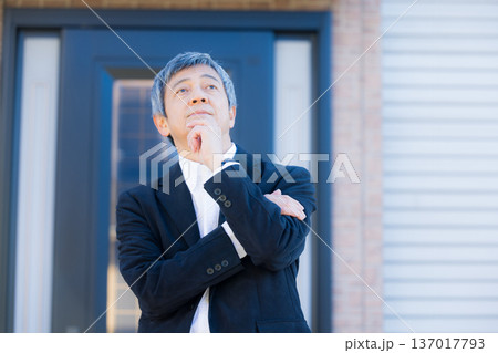社屋建物の前で考える60代男性 社屋建物の前で考える60代男性 137017793