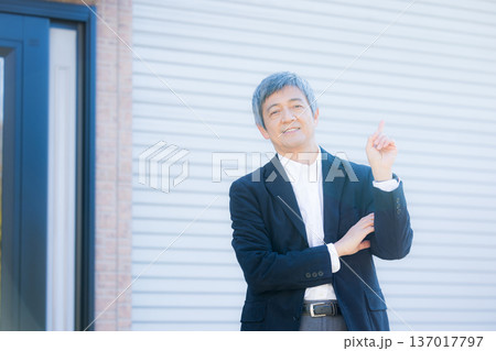 社屋建物の前で考える60代男性 137017797