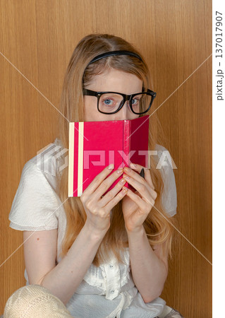 Young stundet ho;ding open book over face 137017907