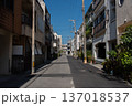 2階、3階建ての建物が両側に並ぶ路地裏の半分が新しく舗装し直された直線の道 137018537