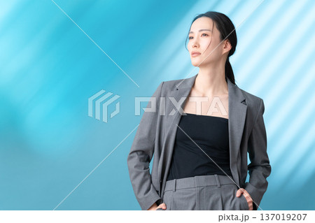 ブルー背景でスキンケアをする女性のビューティーイメージ ブルー背景でスキンケアをする女性のビューティーイメージ 137019207