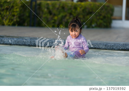 preschool child girl kicking water splashing by legs while practicing swimming in a pool preschool child girl kicking water splashing by legs while practicing swimming in a pool 137019392