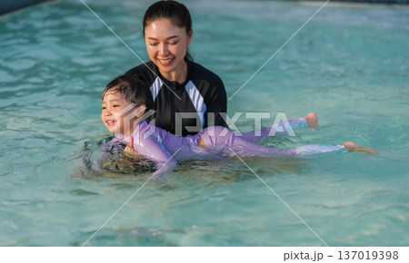preschool child girl playing and swimming with her mother in pool preschool child girl playing and swimming with her mother in pool 137019398