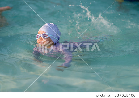 preschool child girl playing and swimming in pool preschool child girl playing and swimming in pool 137019406
