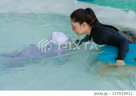 preschool child girl learning to diving with her mother in swimming pool 137019412