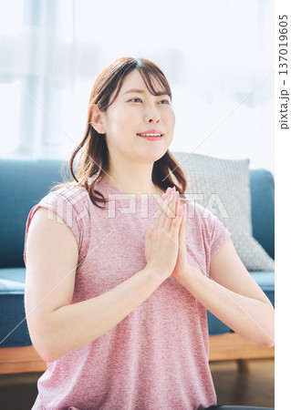 自宅のリビングでヨガポーズをする30代女性のフィットネスライフ 自宅のリビングでヨガポーズをする30代女性のフィットネスライフ 137019605