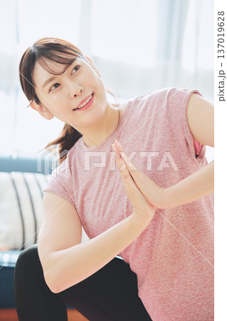 自宅のリビングでヨガポーズをする30代女性のフィットネスライフ 自宅のリビングでヨガポーズをする30代女性のフィットネスライフ 137019628