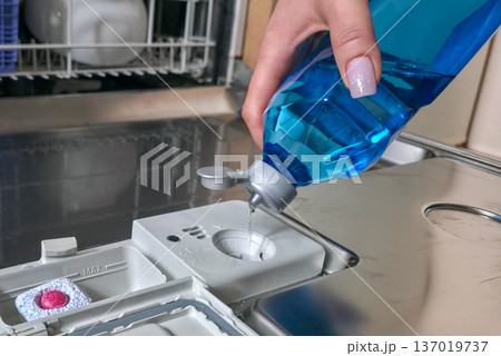 Loading the dishwasher. Tablets and rinse aid to start the dishwasher cycle. High quality photo 137019737