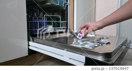 Loading the dishwasher. Tablets and rinse aid to start the dishwasher cycle. High quality photo 137019847