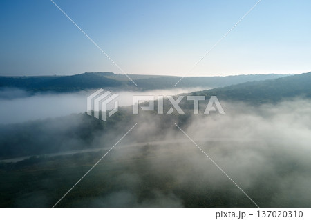 Aerial view from high altitude of earth covered with white puffy cumulus clouds on sunny day Aerial view from high altitude of earth covered with white puffy cumulus clouds on sunny day 137020310