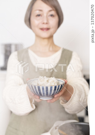 炊きたてのご飯を茶碗によそう手元 137020470