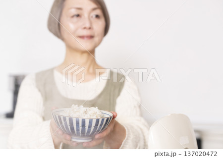 炊きたてのご飯を茶碗によそう手元 137020472