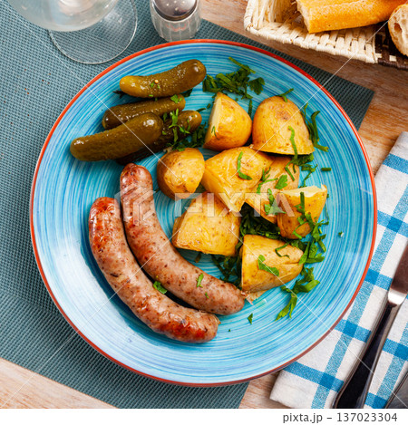 Grilled sausages with boiled potato and gherkins Grilled sausages with boiled potato and gherkins 137023304