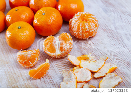 Closeup of fresh peeled clementines on wooden table 137023338