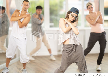 Young girl practicing basic hip hop moves in training hall Young girl practicing basic hip hop moves in training hall 137023407
