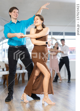 Young couples learning to dance latin american dances in dance studio Young couples learning to dance latin american dances in dance studio 137023421