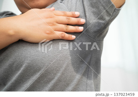 Sweaty underarms, Asian woman with sweat on clothes under armpit. 137023459