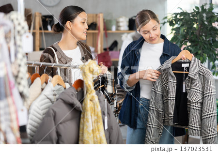 Two elegance women choosing something for autumn-winter season in clothing boutique Two elegance women choosing something for autumn-winter season in clothing boutique 137023531