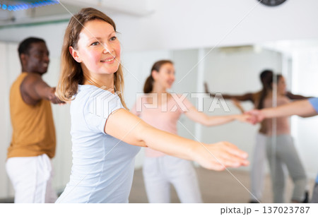 Woman and man practicing modern dance moves in pair during group class Woman and man practicing modern dance moves in pair during group class 137023787