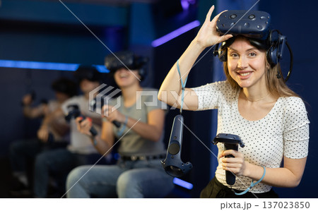 girl is exhilarated by turn of events in VR game and moved virtual reality glasses to forehead girl is exhilarated by turn of events in VR game and moved virtual reality glasses to forehead 137023850