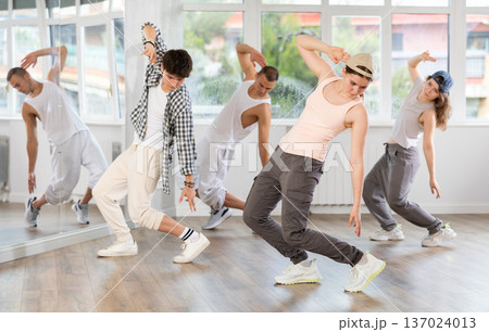 Group of young people perform choreographic exercises and teaches energetic mobile social dance waacking together 137024013