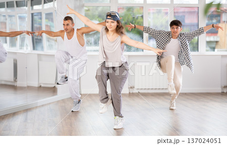 Young girl practicing hip hop reject step in training hall Young girl practicing hip hop reject step in training hall 137024051