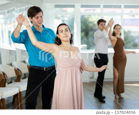 Happy girls paired with guys dance waltz in dance studio 137024056