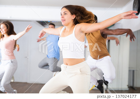 Females and males doing dance workout during group classes in fitness center Females and males doing dance workout during group classes in fitness center 137024177