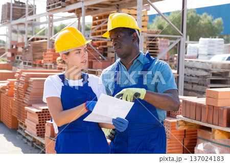 Manager and worker of construction store keep records of brick 137024183