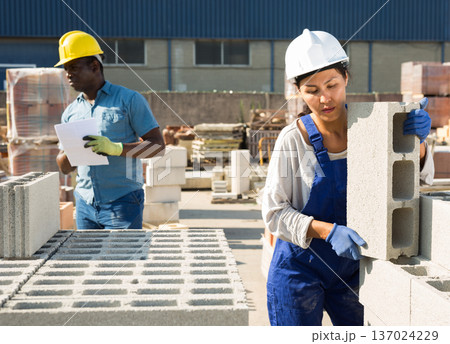 Two builders in construction material storage 137024229