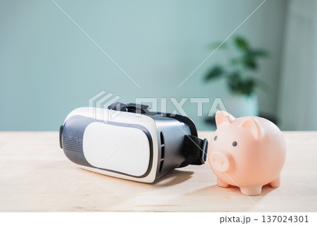 pink piggy bank for money, metaverse banking, casino vr and ar saving concept features technology, virtual reality headset on wooden desk for digital finance and global investment 137024301