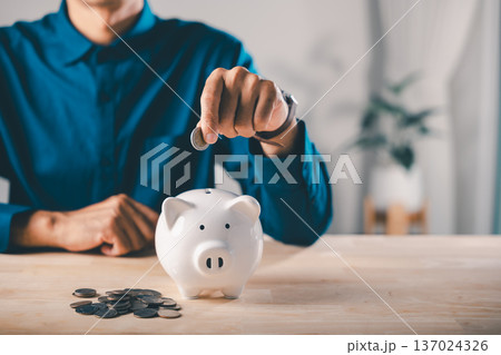 Global economy money bank piggy finance stock growth business concept shows man putting coin into ceramic bank to save for future, economic success requires long term invest goals Global economy money bank piggy finance stock growth business concept shows man putting coin into ceramic bank to save for future, economic success requires long term invest goals 137024326