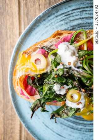 Breakfast served. Delicious bruschetta. Healthy veggie toast with beetroot herbs food. Runny creamy sauce with grilled greens on bread. 137024792