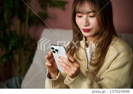 スマホを操作する女性 日本人 室内 ライフスタイル 20代 30代 おうち時間 検索 SNS スマホを操作する女性 日本人 室内 ライフスタイル 20代 30代 おうち時間 検索 SNS 137024896