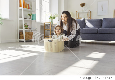 Happy mother playing with child in bright living room, bonding at home Happy mother playing with child in bright living room, bonding at home 137025737