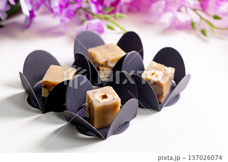Butter caramel fudge squares with hazelnuts and wisteria. 137026074