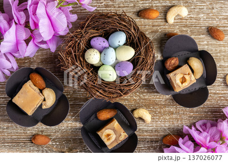 Butter fudge squares with nuts and Easter nest on wood. 137026077