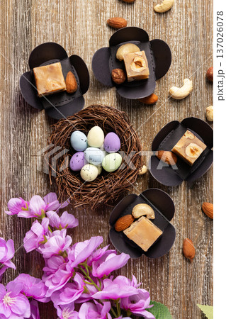 Butter fudge squares with nuts and Easter nest on wood. 137026078