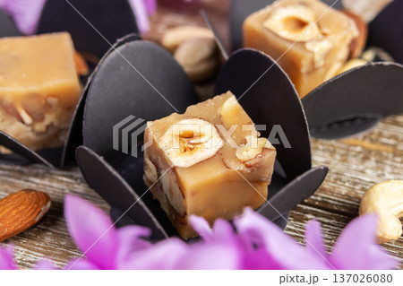 Butter caramel fudge squares with hazelnuts and wisteria. 137026080