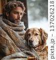 Heartwarming winter scene with man and dog enjoying quiet moment indoors with hot drink, wrapped in blanket. Ideal for pet lifestyle, love, friendship, or hygge lifestyle, comfort, or holiday concept. 137026218