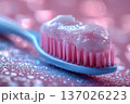 Macro shot of toothbrush with pink toothpaste and water drops. Modern dental care concept for daily oral hygiene, teeth whitening. Bright shiny background with bokeh, professional medical closeup. 137026223