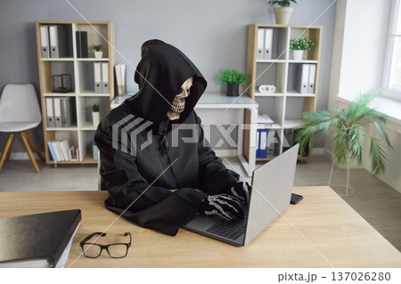 Grim Reaper Using Laptop For Online Activity In Office 137026280