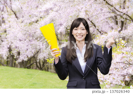桜の前でメガホンを持つOL 137026340