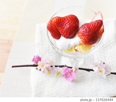 透明なカップにのせた大粒いちごと啓翁桜と梅の花とのクローズアップ 白バック 透明なカップにのせた大粒いちごと啓翁桜と梅の花とのクローズアップ 白バック 137026494